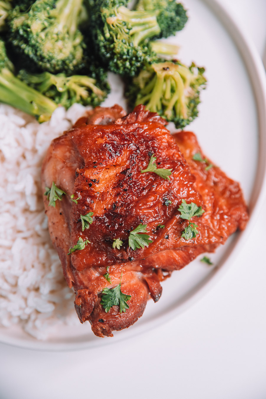 Instant Pot Honey Garlic Chicken with parsley sprinkled on top and a white plate.