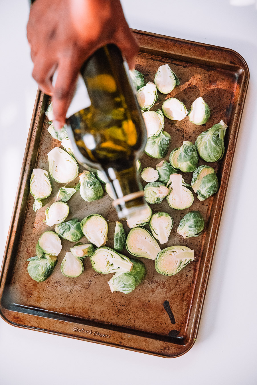 Roasting pan with Brussels Sprouts and olive oil drizzled on top