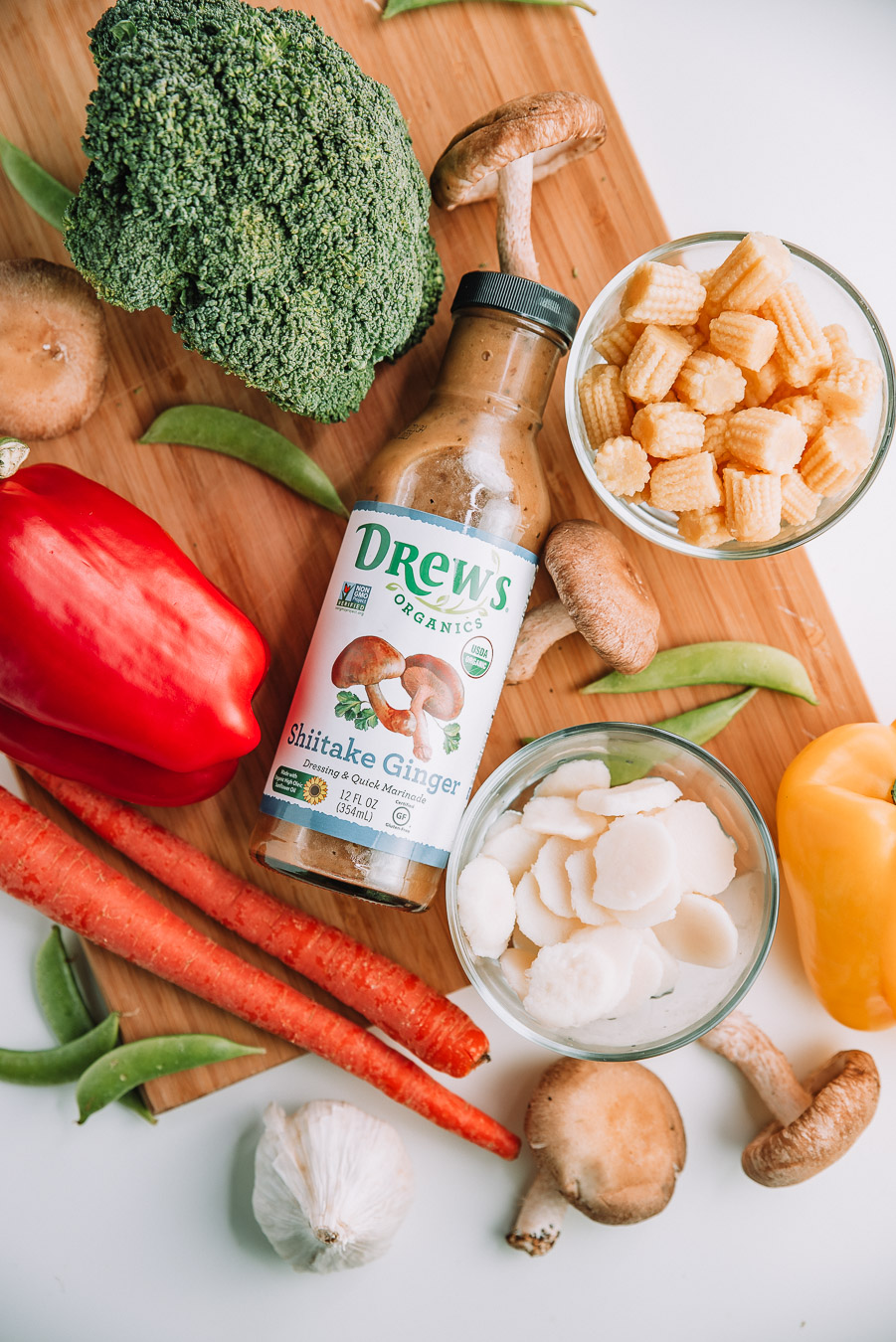 Ingredients for Shiitake Ginger Noodle Stir Fry on a wood cutting board on a white table