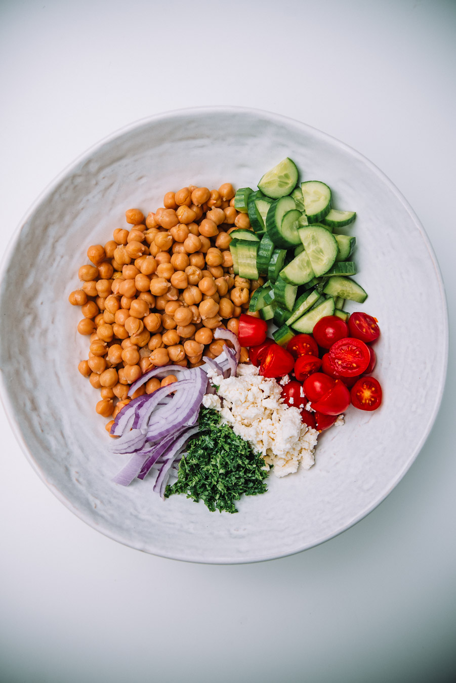 Bowl of Mediterranean Chickpea Salad on a white table