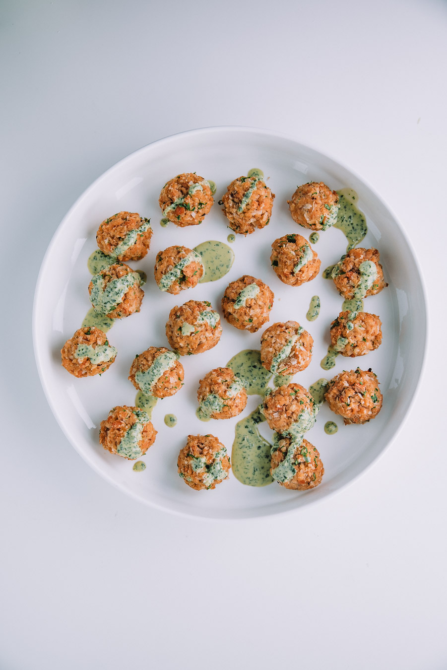 salmon meatballs on a white plate.