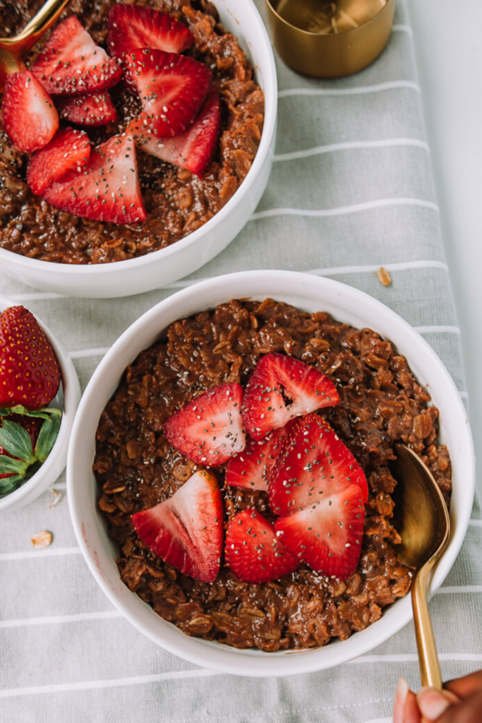 Looking to switch it up with a quick breakfast recipe? Make this easy healthy chocolatey thick batch of chocolate oatmeal made with chia seeds and topped with fresh strawberries. #chocolate #strawberry #oatmeal #breakfast