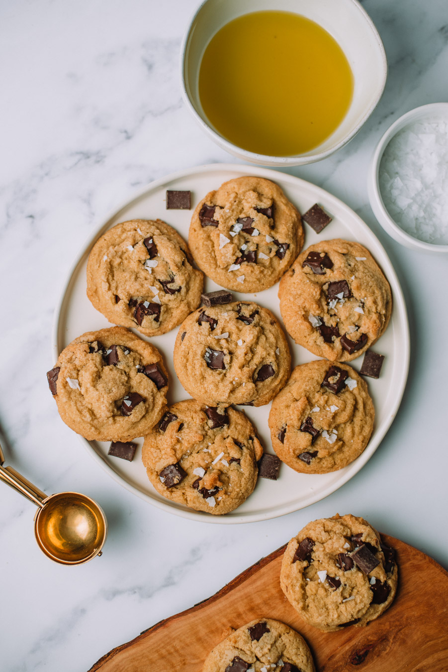 Olive Chocolate Chip Cookies on a round white plate on a marble background. 